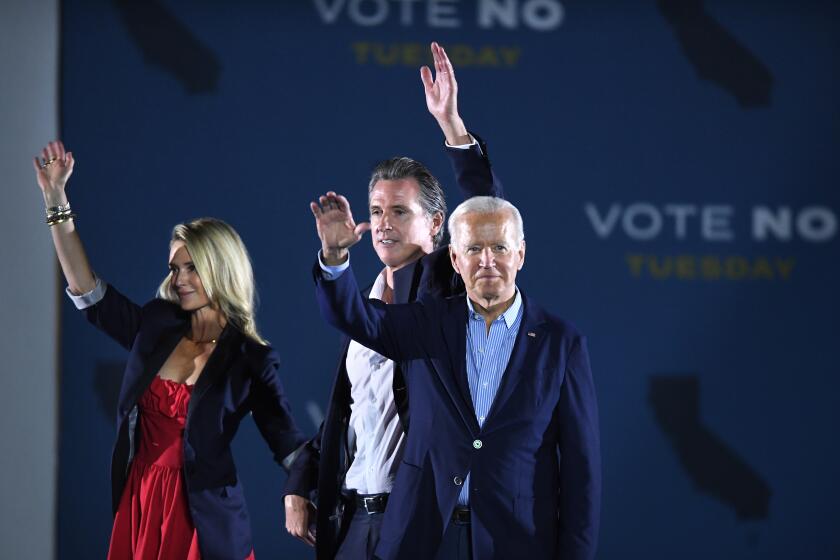 Long Beach, CA - September 13: U.S. US President Joe Biden (L) waves onstage with California Governor Gavin Newsom and his wife Jennifer Siebel Newsom during a campaign event at Long Beach City Collage, on Monday, Sept. 13, 2021 in Long Beach, CA. (Wally Skalij / Los Angeles Times)