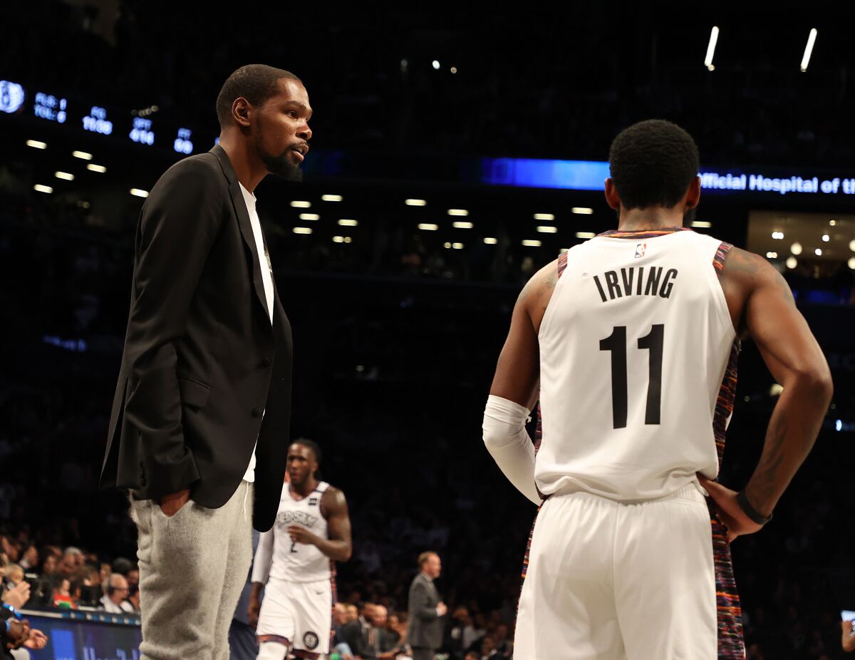 Kevin Durant talks to Kyrie Irving while the two were teammates in Brooklyn.