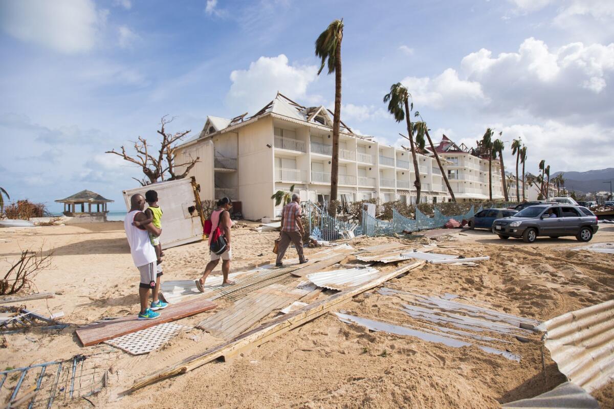 People inspect the damage on a sand-covered street of Marigot, capital of St. Martin, after Hurricane Irma struck the French island territory in the Caribbean.