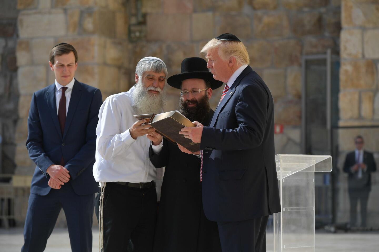 President Trump listens to Rabbi Shmuel Rabinovitch, center, during a visit to the Western Wall, in Jerusalem's Old City. At left is Trump's son-in-law and advisor, Jared Kushner.