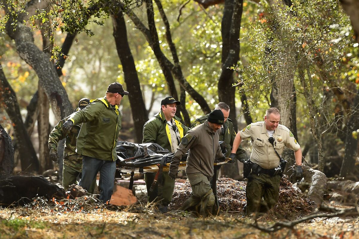 Sheriffs deputies carry a body from the debris near Hot Springs Road in Montecito. (Wally Skalij/Los Angeles Times)