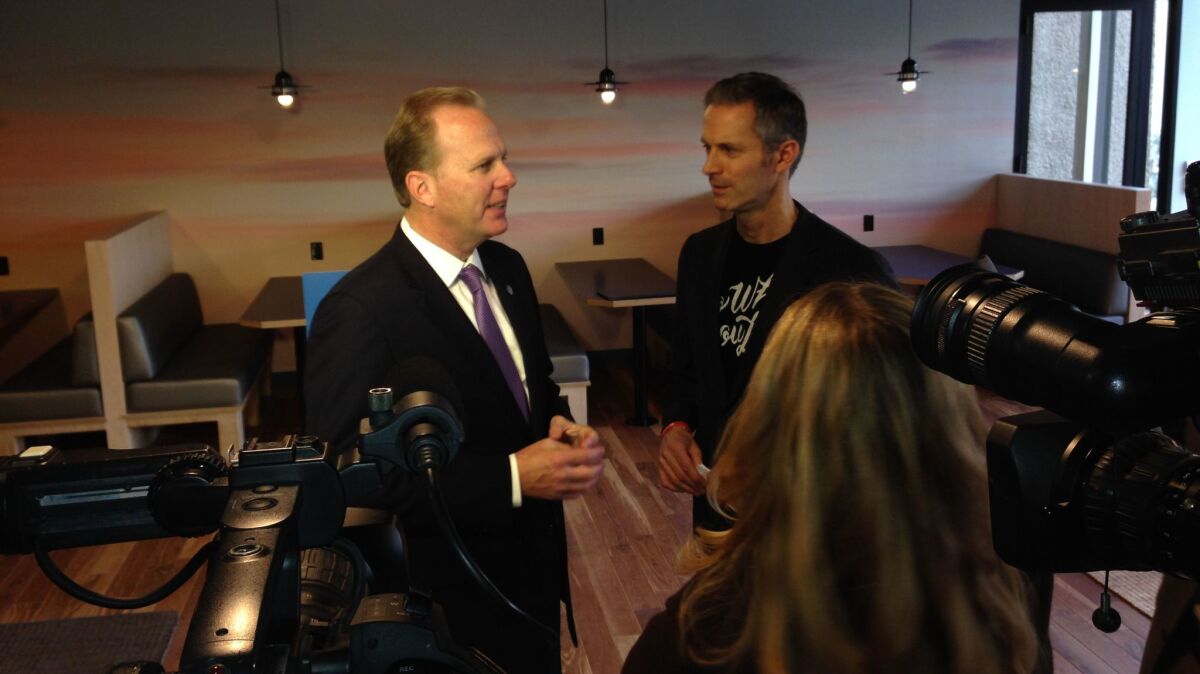 Mayor Kevin Faulconer, left, and Jon Slavet, western regional manager for WeWork, chat at Thursday's official opening of the company's downtown headquarters.