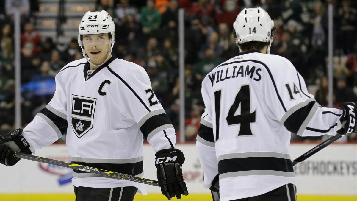 Kings captain Dustin Brown, left, smiles while skating next to teammate Justin Williams during the second period of a 4-0 win over the Minnesota Wild on Wednesday.