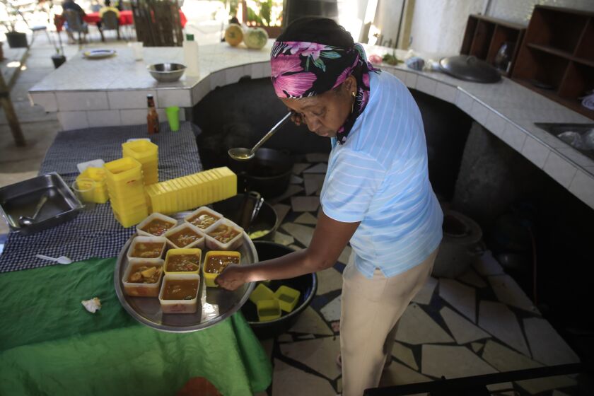 Mireille Lerebours sirve la tradicional sopa joumou en un restaurante del distrito Delmas, el domingo 5 de febrero de 2023, en Puerto Príncipe, Haití. (AP Foto/Odelyn Joseph)