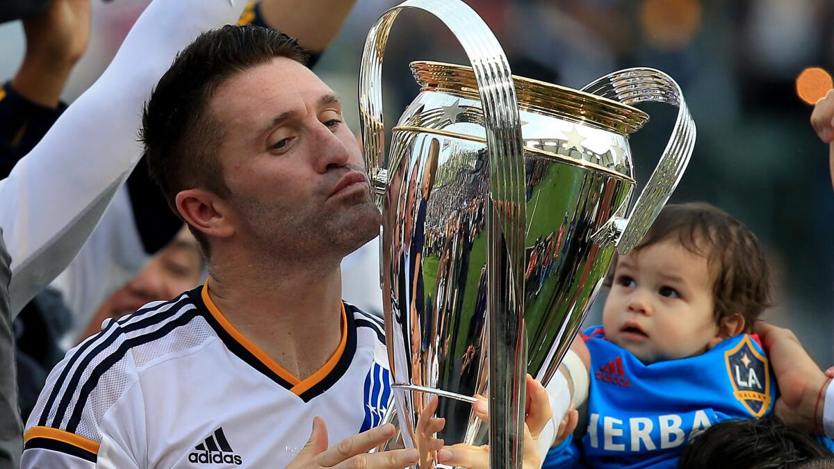 Galaxy forward Robbie Keane kisses the MLS Cup trophy after the team's victory over the New England Revolution in the MLS Cup final on Dec. 7.