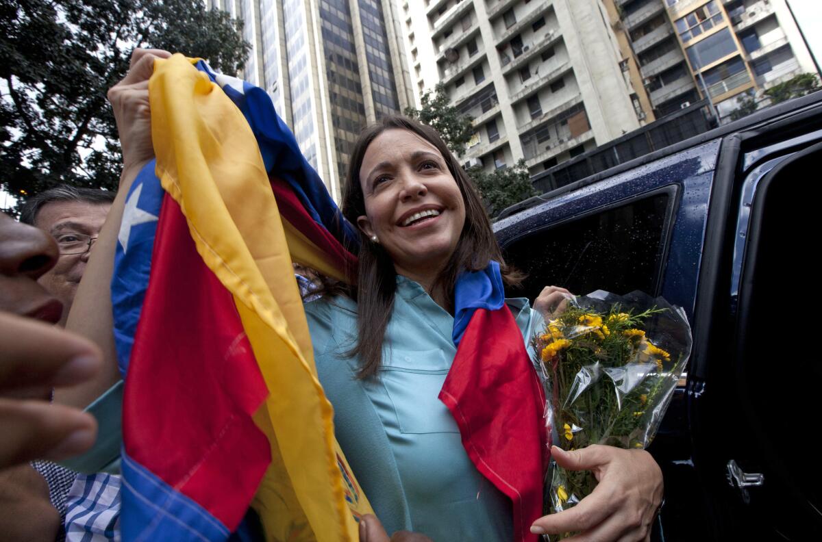 Opposition leader Maria Corina Machado holds up the Venezuelan flag outside the office of the attorney general in Caracas, Venezuela, on Wednesday.