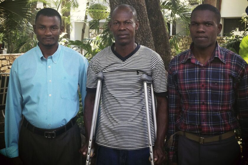 FILE - In this photograph provided by attorney Ela Matthews, David Boniface, Nissage Martyr and Juders Yseme, from left, pose together in January 2014, in Haiti. An attorney for the three Haitian men who claimed in a U.S. lawsuit that the former mayor of their small hometown subjected his political opponents to violence and terror called the defendant “a small, petty tyrant” during closing arguments Monday, March 20, 2023. (Courtesy of Ela Matthews/Center for Justice & Accountability via AP, File)