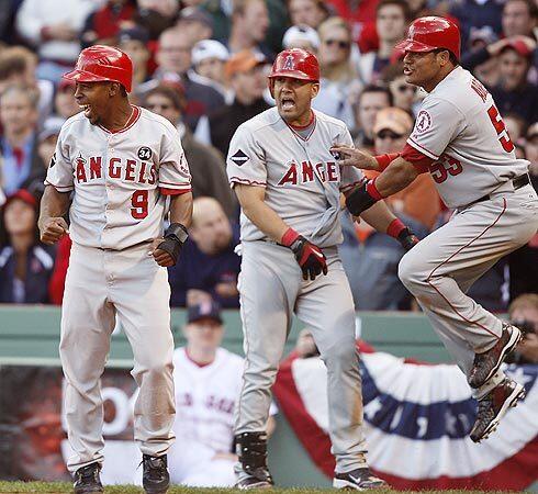 Chone Figgins, left, Kendry Morales and Bobby Abreu celebrate as they score the winning runs in the top of the ninth inning.