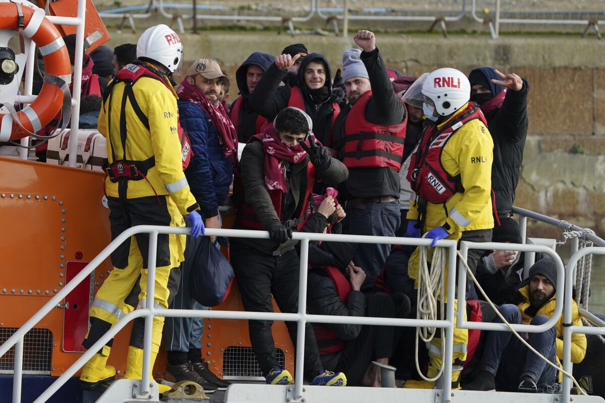 A group of people thought to be migrants are brought in to Dover, Kent, Britain, by the RNLI following a small boat incident in the Channel, Tuesday Jan. 4, 2022. At least 28,300 people packed into small boats crossed the Channel from France to England’s south coast in 2021, an annual record that was three times the number of crossings a year earlier. The leap in numbers, reported by the Press Association news agency based on data from Britain's Home Office, reflects the soaring number of migrants seeking to cross the world’s busiest shipping lane often in flimsy boats provided by people smugglers. (Gareth Fuller/PA via AP)