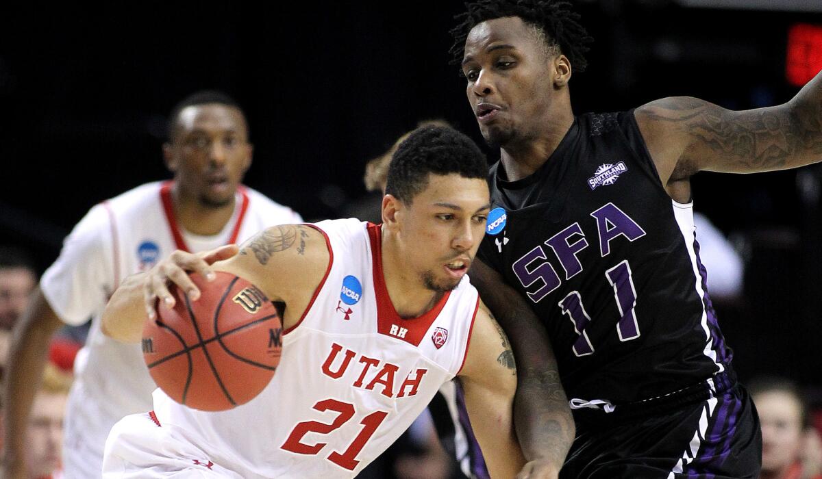 Utah forward Jordan Loveridge drives on Stephen F. Austin forward Clide Geffrard in the second half of the Utes' 57-50 victory on Thursday night.