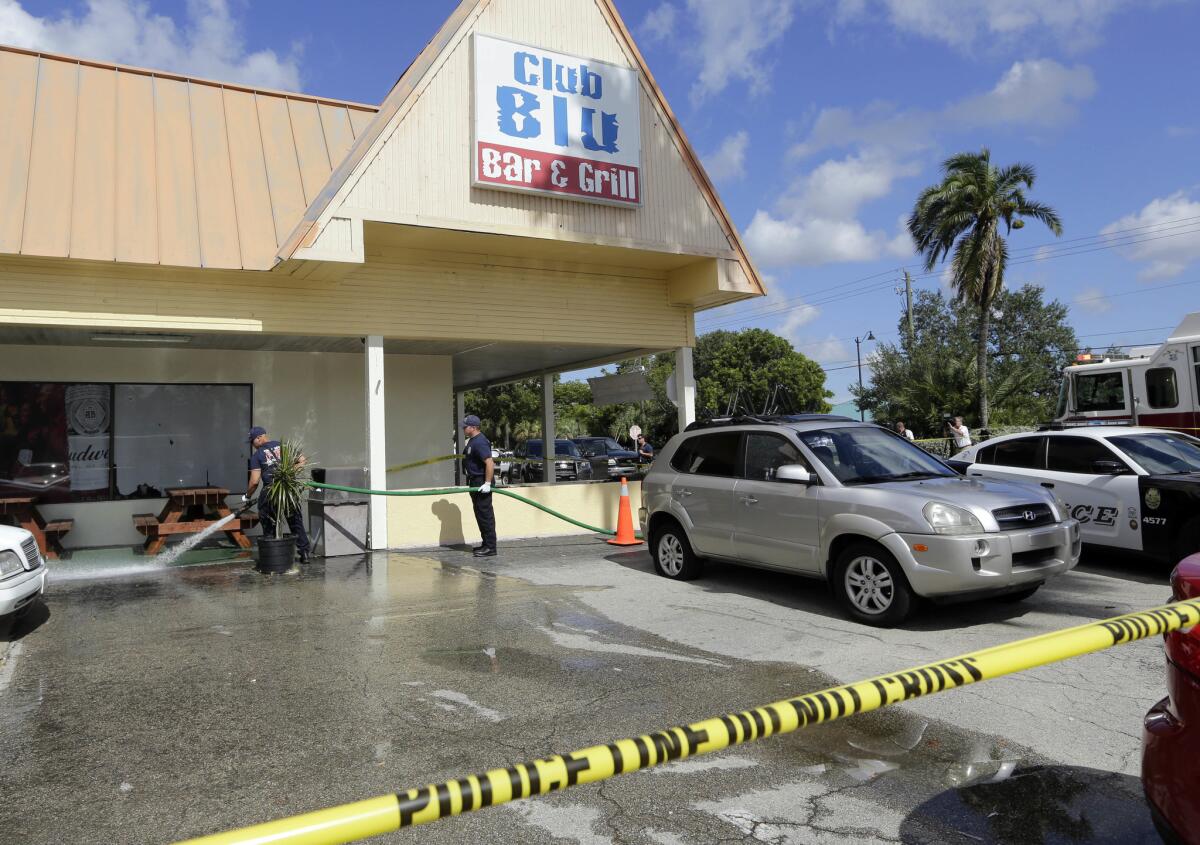 Firefighters hose down the pavement at the scene of a deadly shooting at the Club Blu nightclub in Fort Myers, Fla., on Monday.