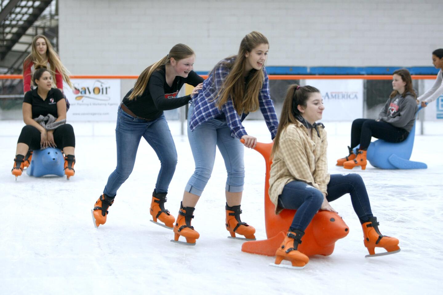 Village Christian students, from left, Olivia, Brooke and Michaela, push each other in a line on opening day at the Rink in downtown Burbank on Thursday, Dec. 15, 2016.