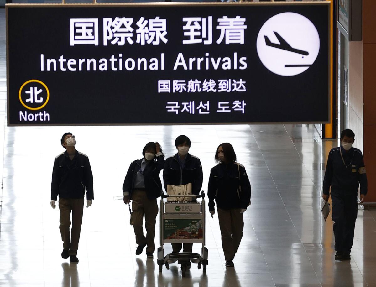 Passengers walk through the international arrivals area at Kansai International Airport in Osaka, Japan.
