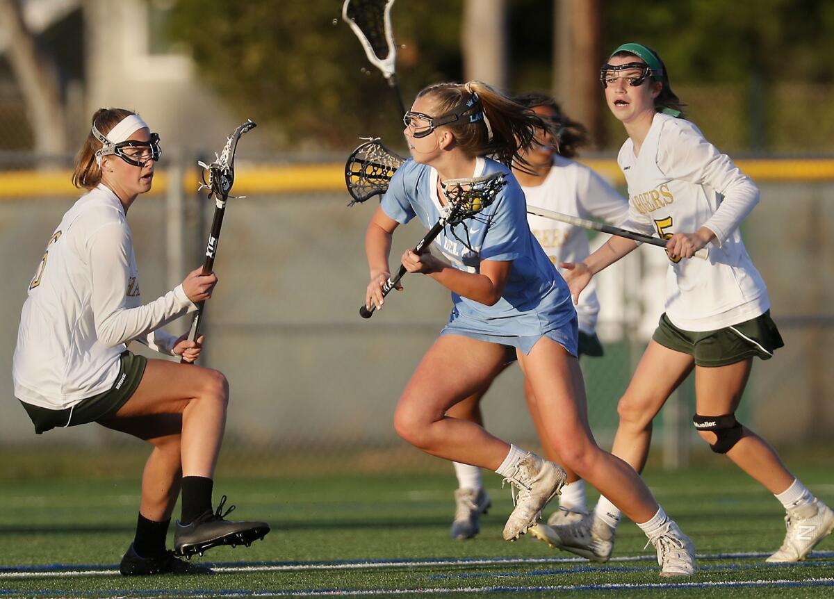 Corona del Mar High's Joslyn Simaan, center, carries the ball during the first half of a Sunset League game at Edison on Thursday.
