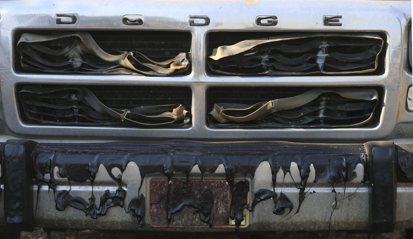 The front grille and bumper of an older Dodge pickup truck was melted by the heat of the fire in Escondido.