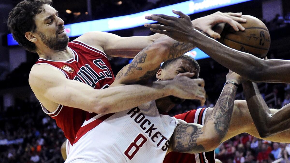 Michael Beasley (8) tangles with Bulls center Pau Gasol while trying to get a rebound for the Rockets last season.