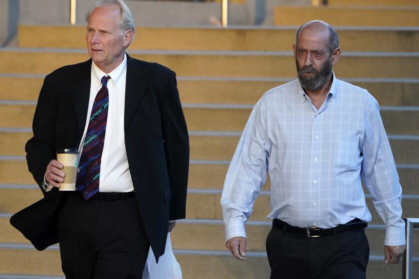 Defendant Jerry Boylan, right, captain of a scuba dive boat called the Conception, arrives in Federal court in Los Angeles, Tuesday, Oct. 24, 2023. Federal prosecutors are seeking justice for 34 people killed in a fire aboard the boat in 2019. The trial against Boylan began Tuesday, with jury selection. Boylan has pleaded not guilty to one count of misconduct or neglect of ship officer. (AP Photo/Damian Dovarganes)