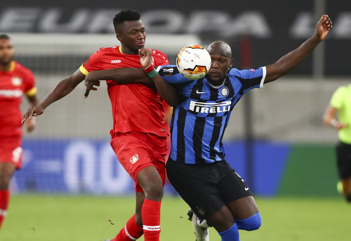 Leverkusen's Edmond Tapsoba and Inter Milan's Romelu Lukaku, right, battle for the ball during the Europa League quarterfinal match between Inter Milan and Bayer Leverkusen at the Duesseldorf Arena in Dusseldorf, Germany, Monday, Aug. 10, 2020. (Dean Mouhtaropoulos, Pool Photo via AP)