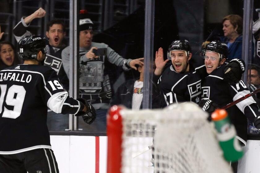 Los Angeles Kings left wing Tanner Pearson, right, celebrates his overtime goal with defenseman Alec Martinez, second from right, and center Alex Iafallo, against the Carolina Hurricanes in an NHL hockey game in Los Angeles, Saturday, Dec. 9, 2017. The Kings won 3-2. (AP Photo/Alex Gallardo)