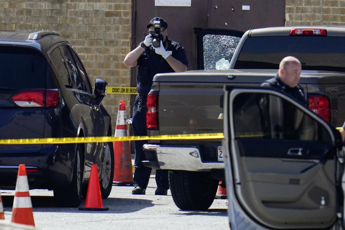 Shattered glass is seen on a pickup's driver side door as investigators document the scene in a mall parking area where two Baltimore city police officers were shot and a suspect was killed as a U.S. Marshals’ task force served a warrant, Tuesday, July 13, 2021, in Baltimore, Md. The police officers were taken to the University of Maryland Medical Center with injuries that aren’t thought to be life-threatening, county police spokeswoman Joy Stewart said.(AP Photo/Julio Cortez)