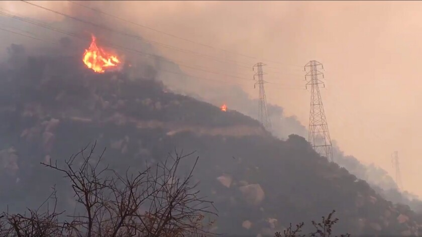 FILE - In this Saturday, Dec. 16, 2017, file image taken from video provided by the Santa Barbara County Fire Department, spot fires burn near power lines as heavy smoke fills the air from a wildfire in Santa Barbara, Calif. The nation's largest utility, Pacific Gas & Electric is poised to emerge from five years of criminal probation amid worries that it remains too dangerous to be trusted. Over the five years, the utility became an even more destructive force. More than 100 people have died and thousands of homes and businesses have been incinerated in wildfires sparked by its equipment in that time. (Mike Eliason/Santa Barbara County Fire Department via AP, File)