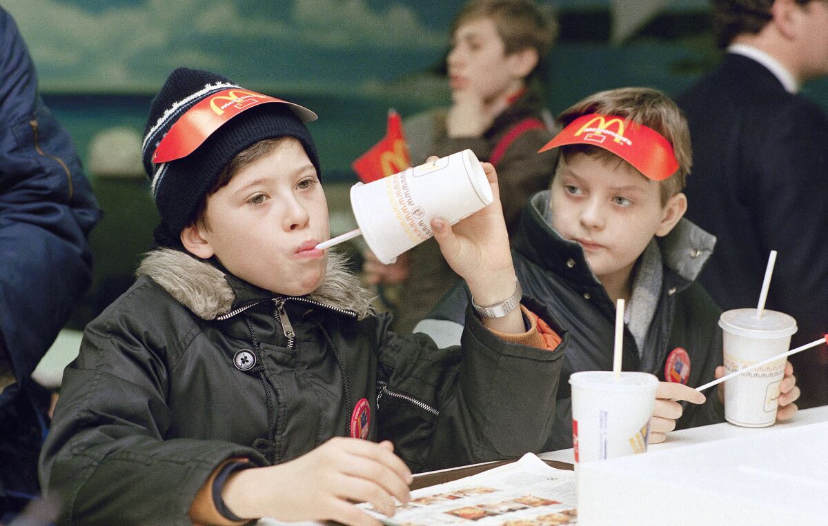FILE - Young Muscovites checks out a new taste sensation for the Soviet Union, hamburgers and soft drinks in Moscow on Jan. 31, 1990. McDonald’s said Thursday, May 19, 2022, it has begun the process of selling its Russian business to one of its licensees in the country. The Chicago burger giant said Alexander Govor, who operates 25 restaurants in Siberia, has agreed to buy McDonald’s 850 Russian restaurants and operate them under a new brand. McDonald’s didn’t disclose the sale price. (AP Photo/Rudi Blaha, File)