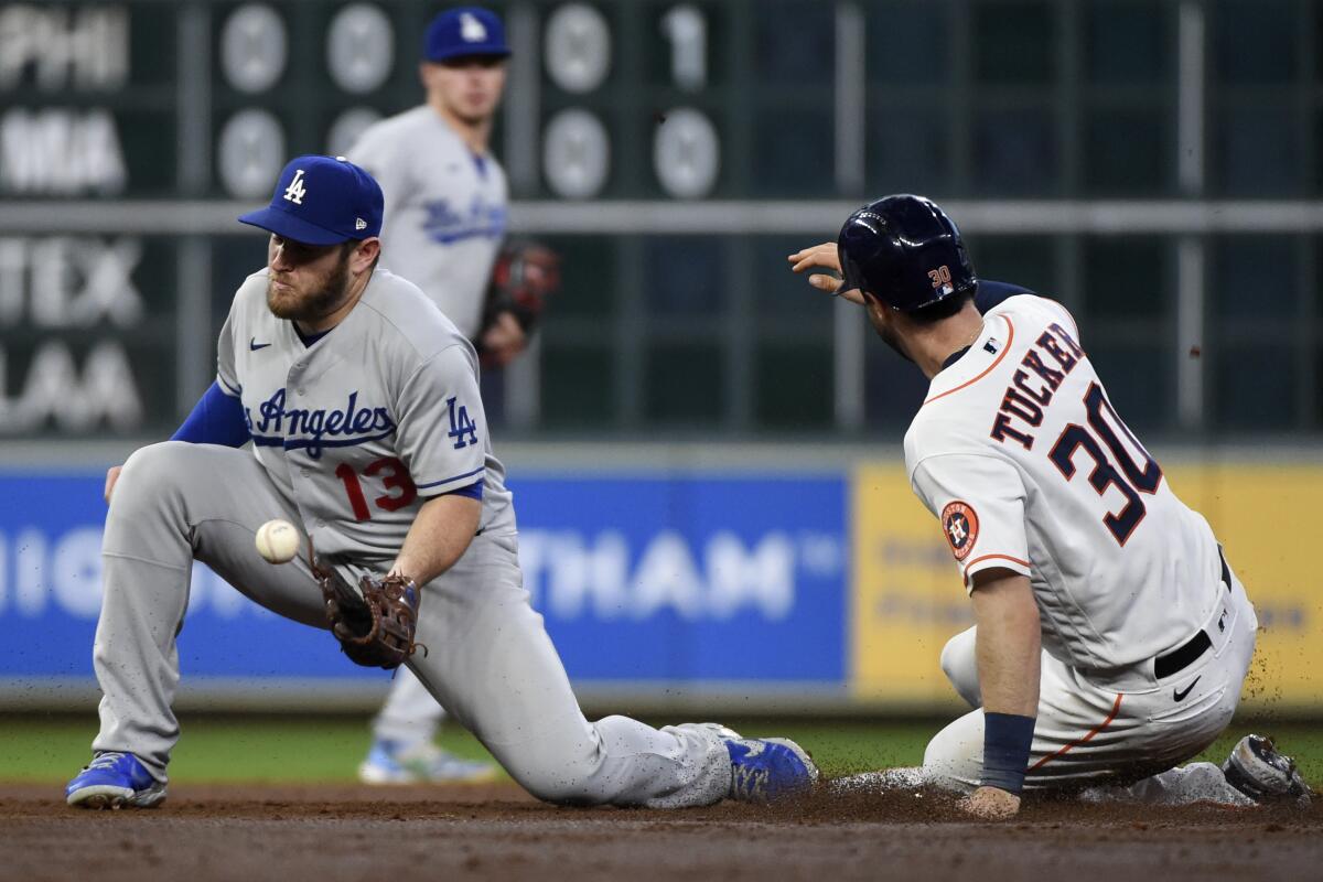 Houston Astros' Kyle Tucker steals second as Dodgers second baseman Max Muncy makes the catch.