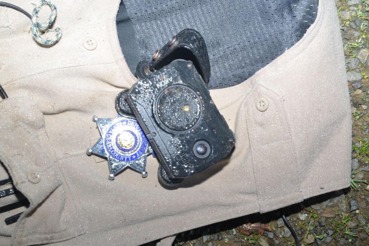 A close-up of a sheriff's deputy star and body camera