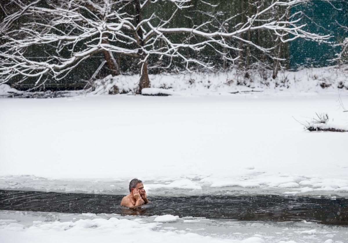 Un hombre nada en agua helada en el parque de Serebryany Bor