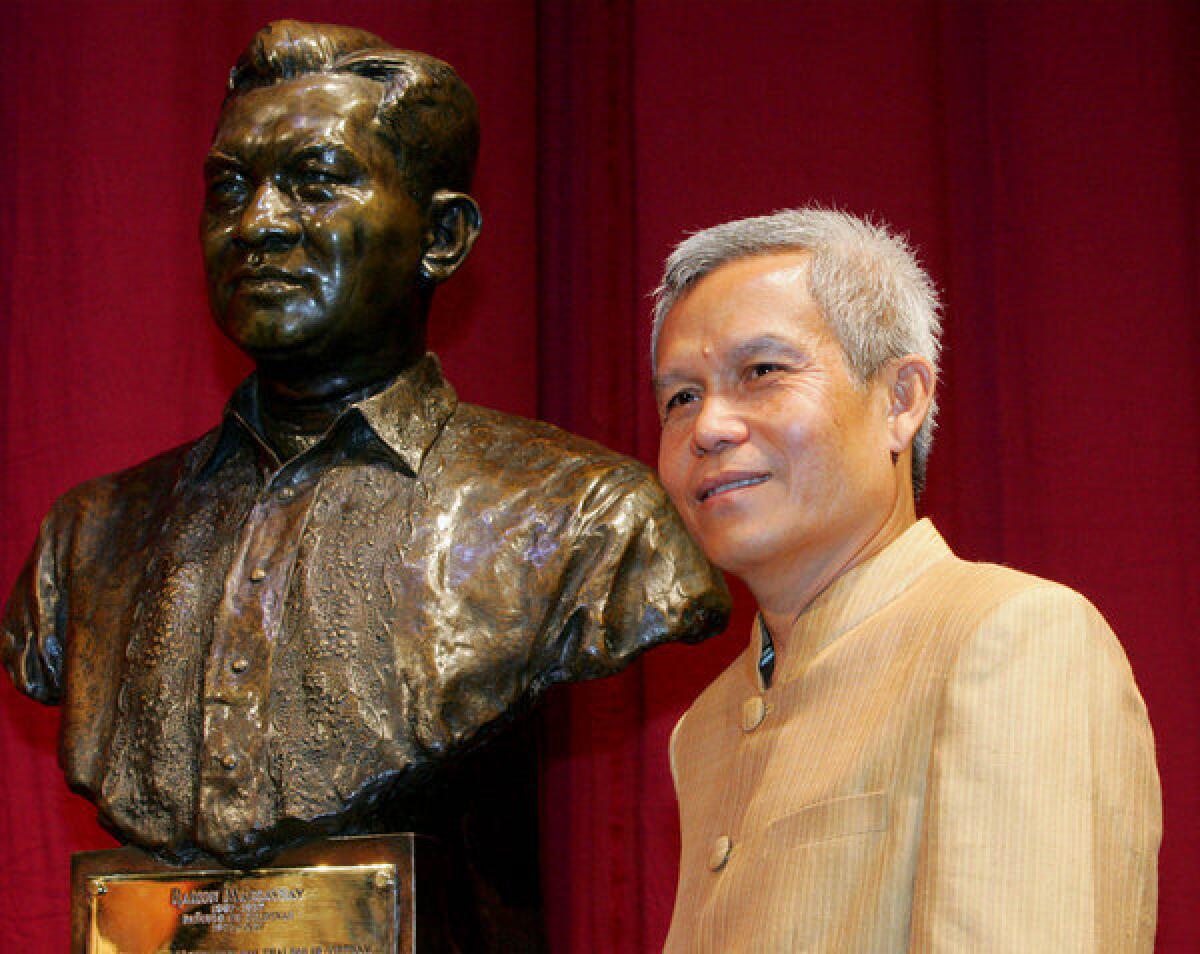 Laotian activist Sombath Somphone in 2005, posing with the bust of the late Philippine President Ramon Magsaysay before receiving the Ramon Magsaysay Award for Community Leadership at the Cultural Center of the Philippines in Manila.