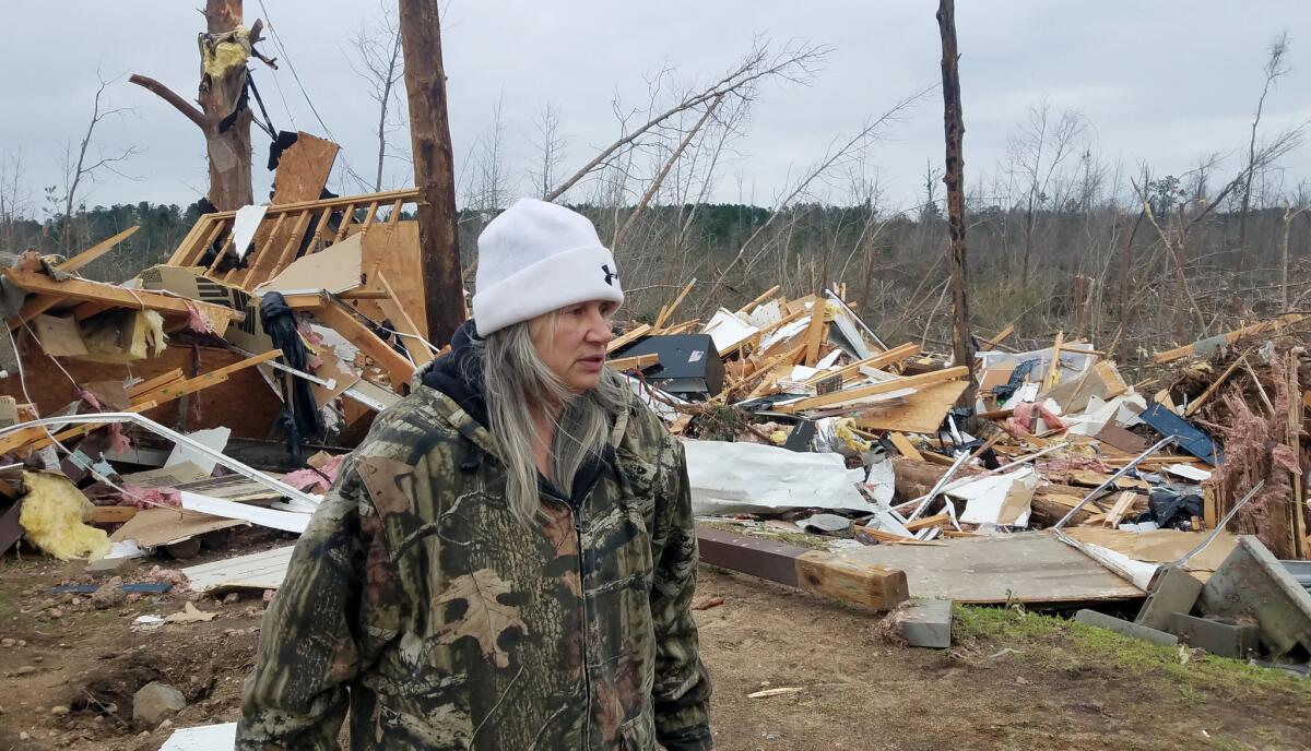 Julie Morrison looks at the debris of her destroyed house in Beauregard, Ala., on Monday. Morrison and her husband sheltered in their bathtub Sunday as the tornado lifted their 2,100-square-foot home and tossed it into the woods.