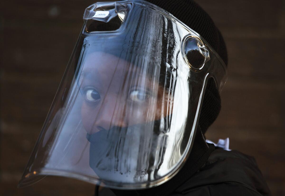 A student, wearing a face mask and shield, returns to school in Johannesburg, South Africa.