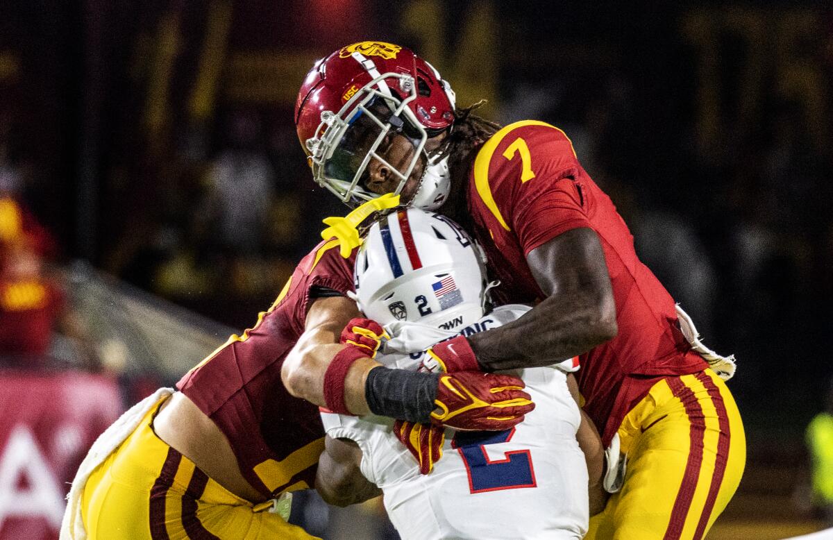 USC safety Calen Bullock takes down Arizona receiver Jacob Cowing with help from linebacker Mason Cobb 