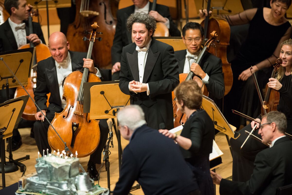 Pianist Emanuel Ax rolls out a cake for Gustavo Dudamel's 36th birthday following the the Los Angeles Philharmonic performance at the Walt Disney Concert Hall on Thursday night