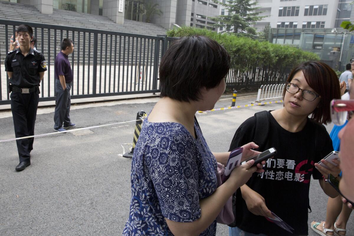 Women's rights activist Wei Tingting, right, waits outside a Beijing court on July 31, 2014.