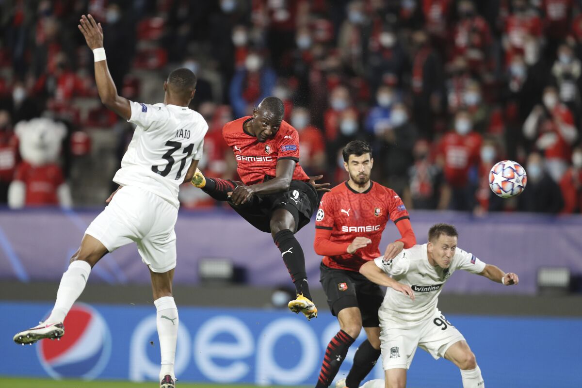 Rennes' Serhou Guirassy, centre, heads the ball during the Champions League, group E soccer match between Rennes and Krasnodar at the Roazhon Park stadium in Rennes, France, Tuesday, Oct. 20, 2020. (AP Photo/David Vincent)
