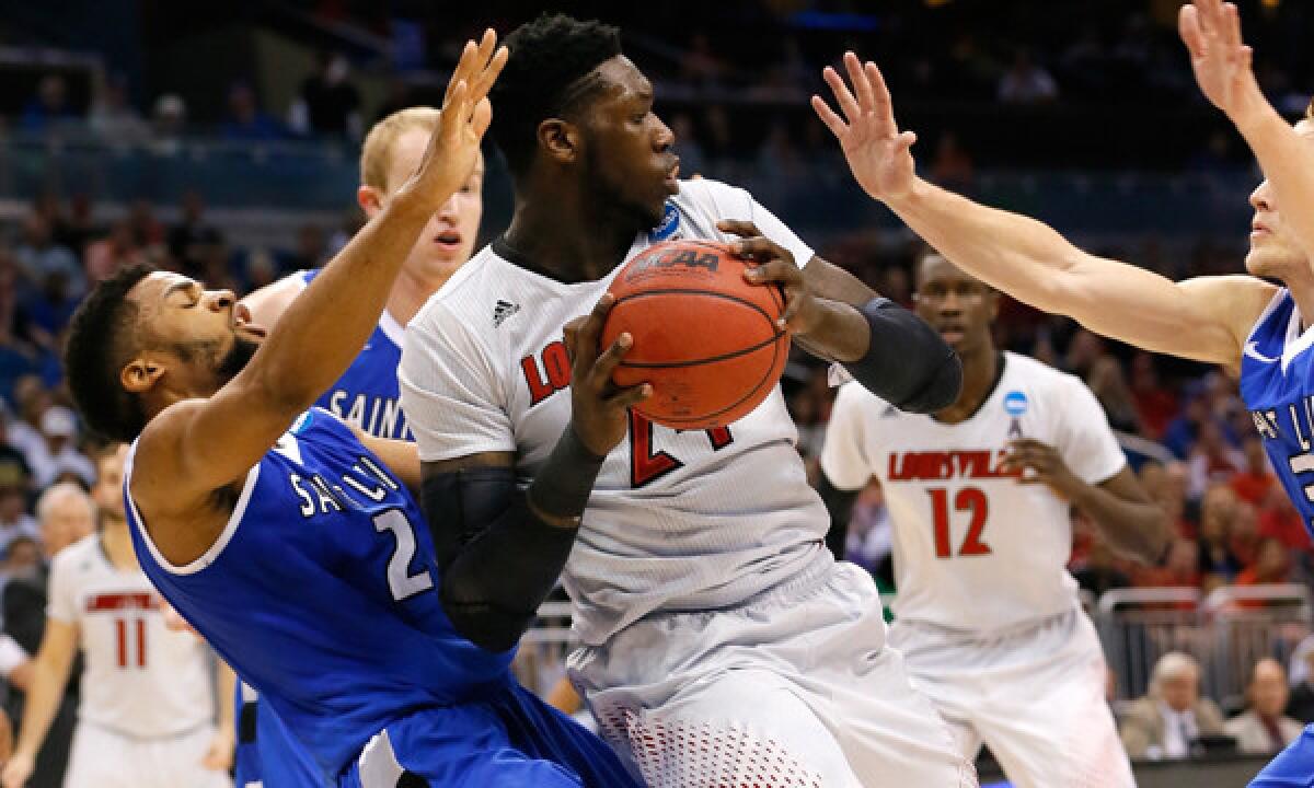 Louisville's Montrezl Harrell, right, is guarded by Saint Louis' Dwayne Evans as he looks to pass during the Cardinals' 66-51 victory Saturday in the third round of the NCAA tournament.