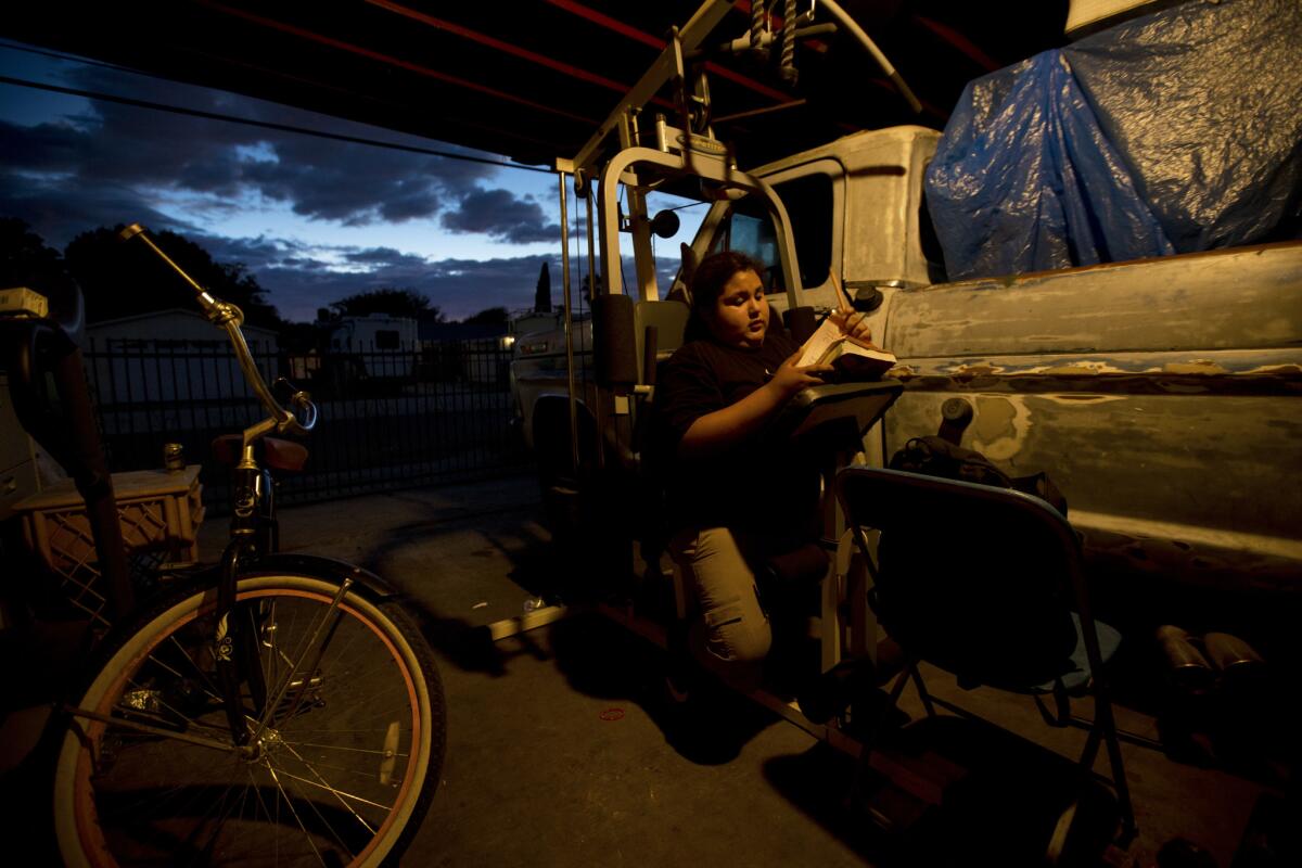 Jesus Rosales finds a quiet spot to do math homework outside his crowded home in Pacoima. The 11-year-old is a fifth-grader at Telfair Elementary School.