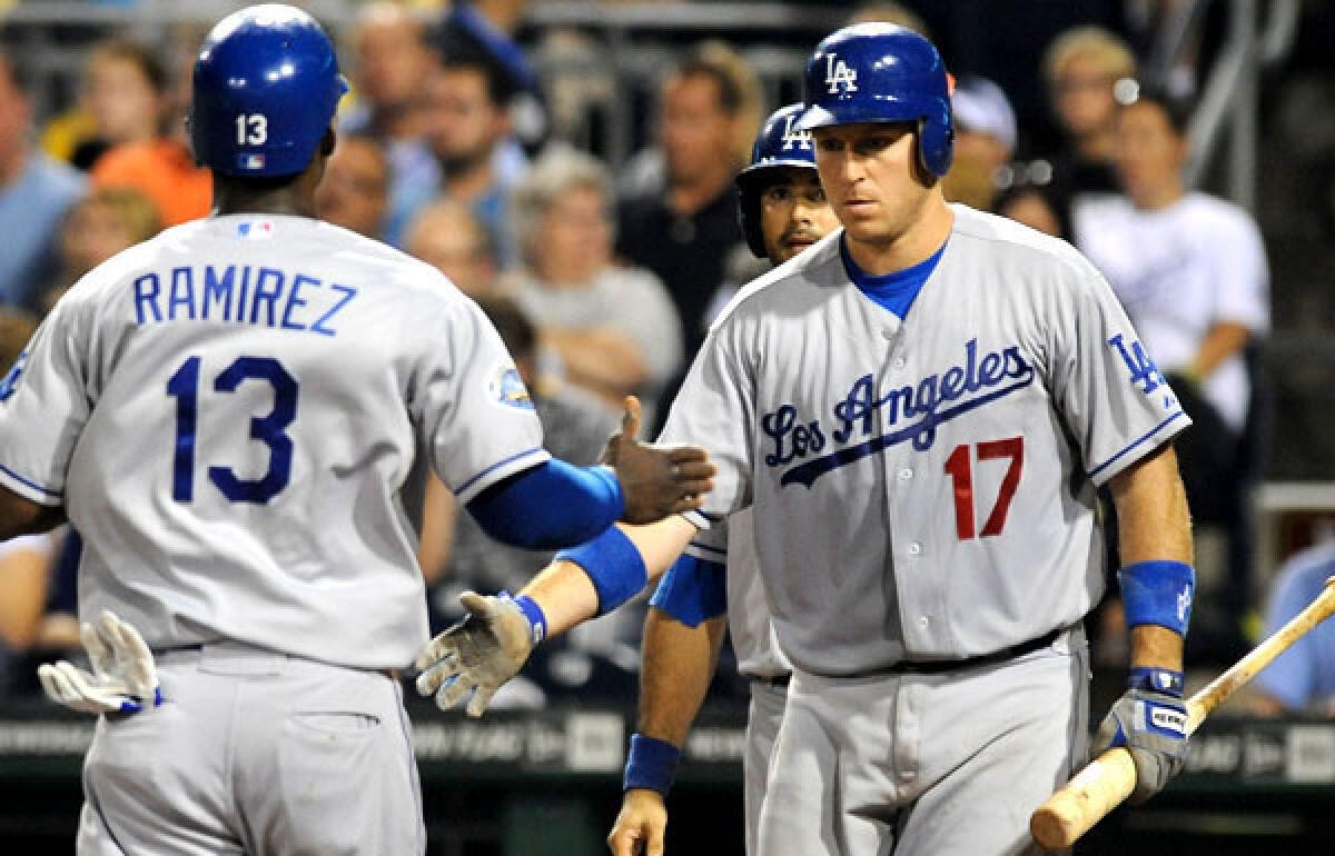 Dodgers catcher A.J. Ellis congratulates teammate Hanley Ramirez after he scored against the Pirates during a game last month.