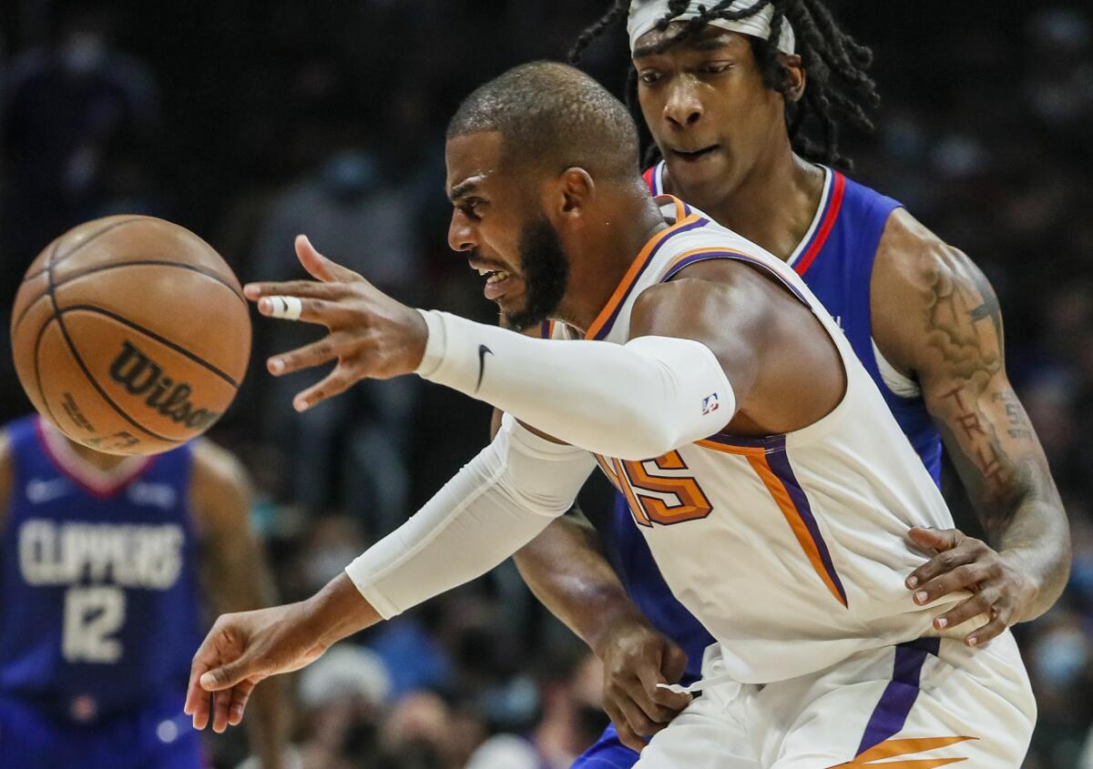 Clippers guard Terance Mann, top, fouls Phoenix Suns guard Chris Paul in the first half.