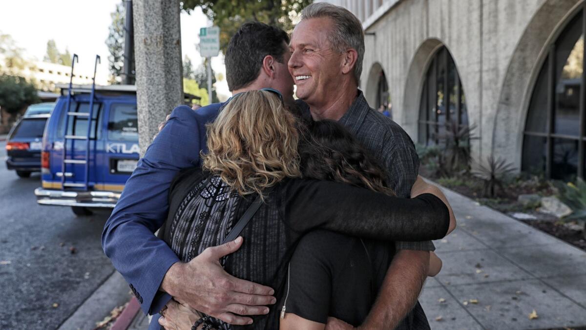 Frank O'Connell receives a group hug outside Superior Court after the Los Angeles County Board of Supervisors approved a $15-million payment after spending nearly three decades behind bars.