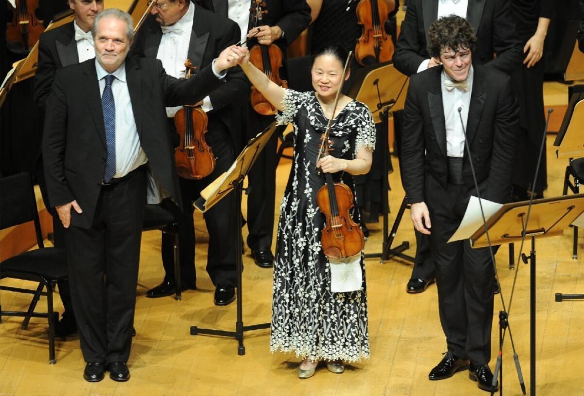 Violinist Midori takes a curtain call with composer Peter Eotvos, left, for the Los Angeles Philharmonic world premiere of "DoReMi" in January. She'll perform it at the Proms.