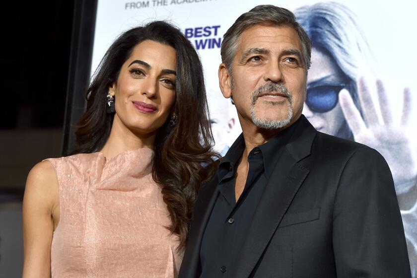Amal and George Clooney, shown at the "Our Brand Is Crisis" premiere on Oct. 26, have adopted a 4-year-old shelter dog.