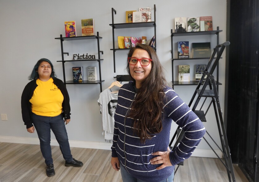 Assistant Marilynn Montano and owner Sarah Rafael Garcia stand in the new Libro Mobile bookstore location in Santa Ana.
