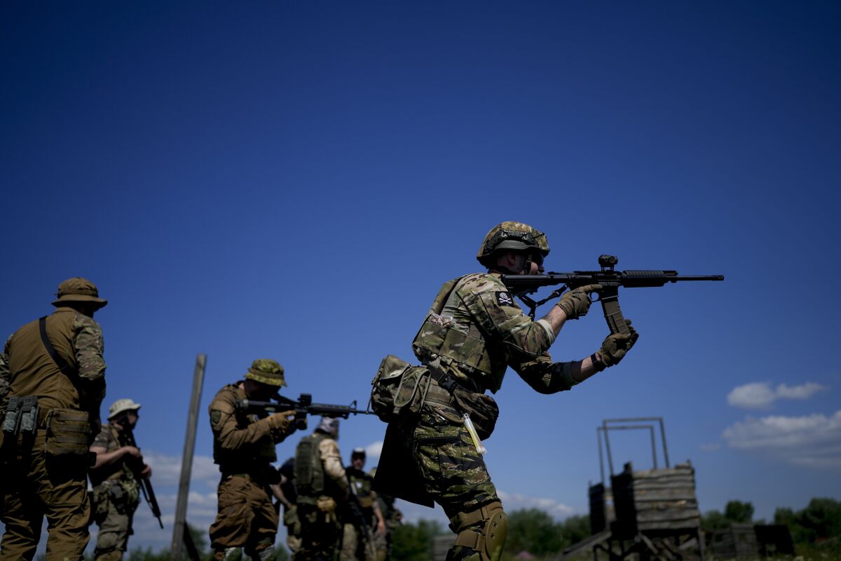 Civilian militia men hold rifles during training at a shooting range in outskirts Kyiv, Ukraine, Tuesday, June 7, 2022. (AP Photo/Natacha Pisarenko)