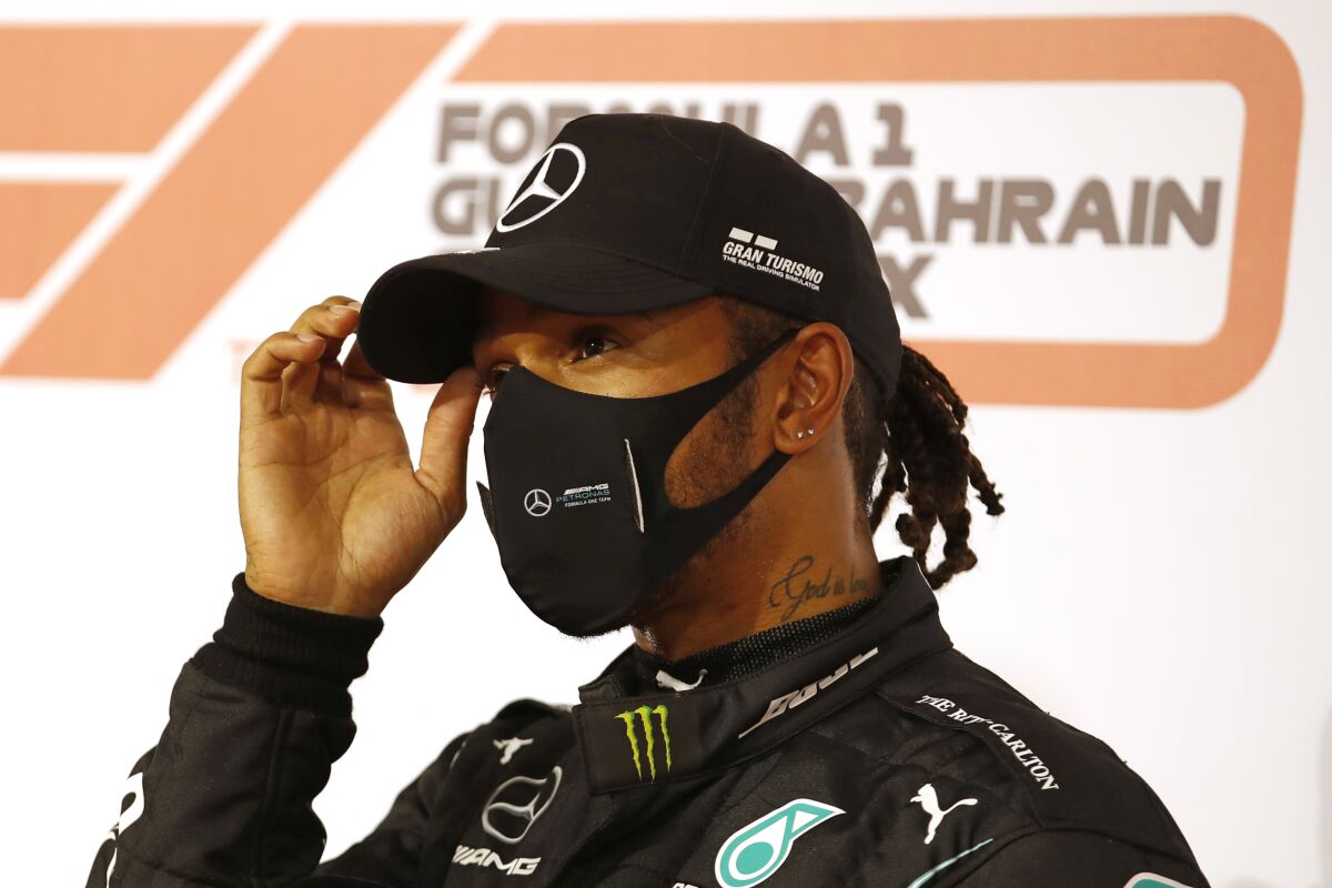 Formula One champion Lewis Hamilton in a hat and mask