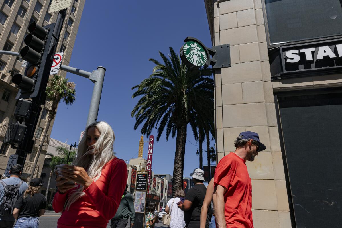 Pedestrians walk by a Starbucks in Hollywood. 