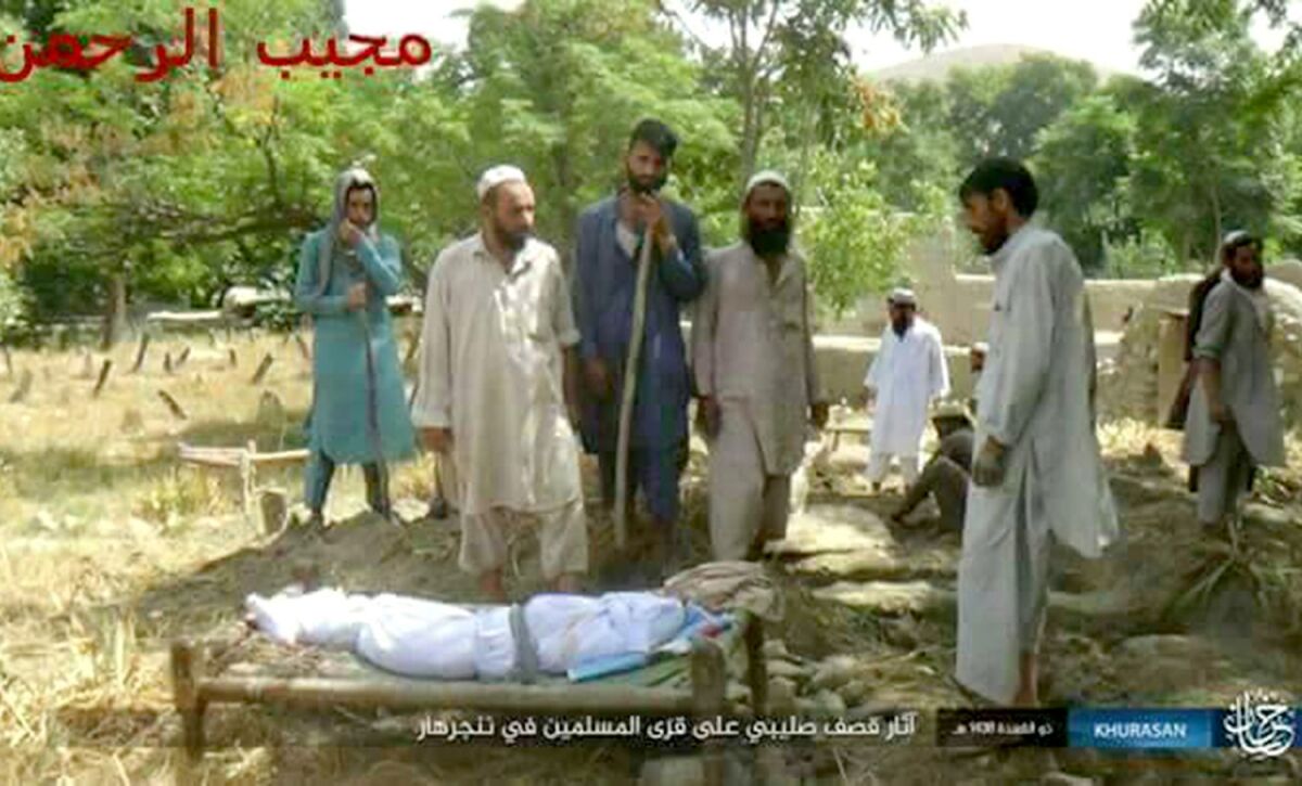 An Islamic State broadcast shows Mohammad Agha, second from left, conducting a burial for the victims.
