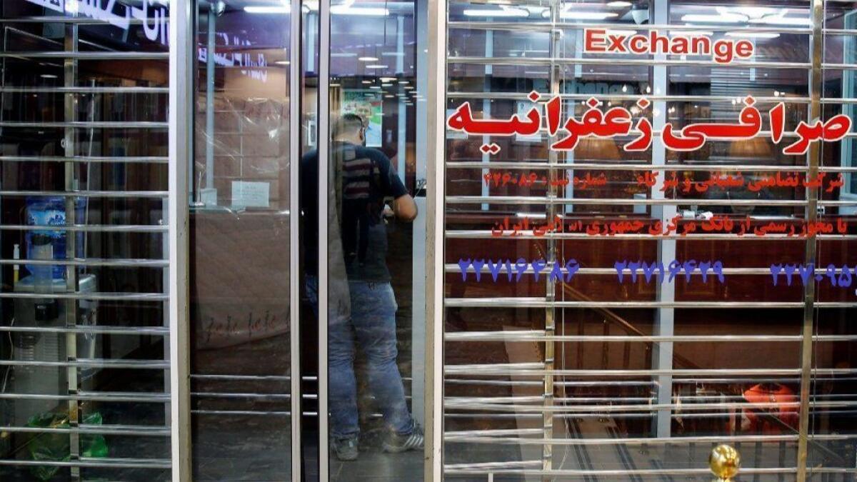 An Iranian man stands inside a money exchange shop in Tehran.