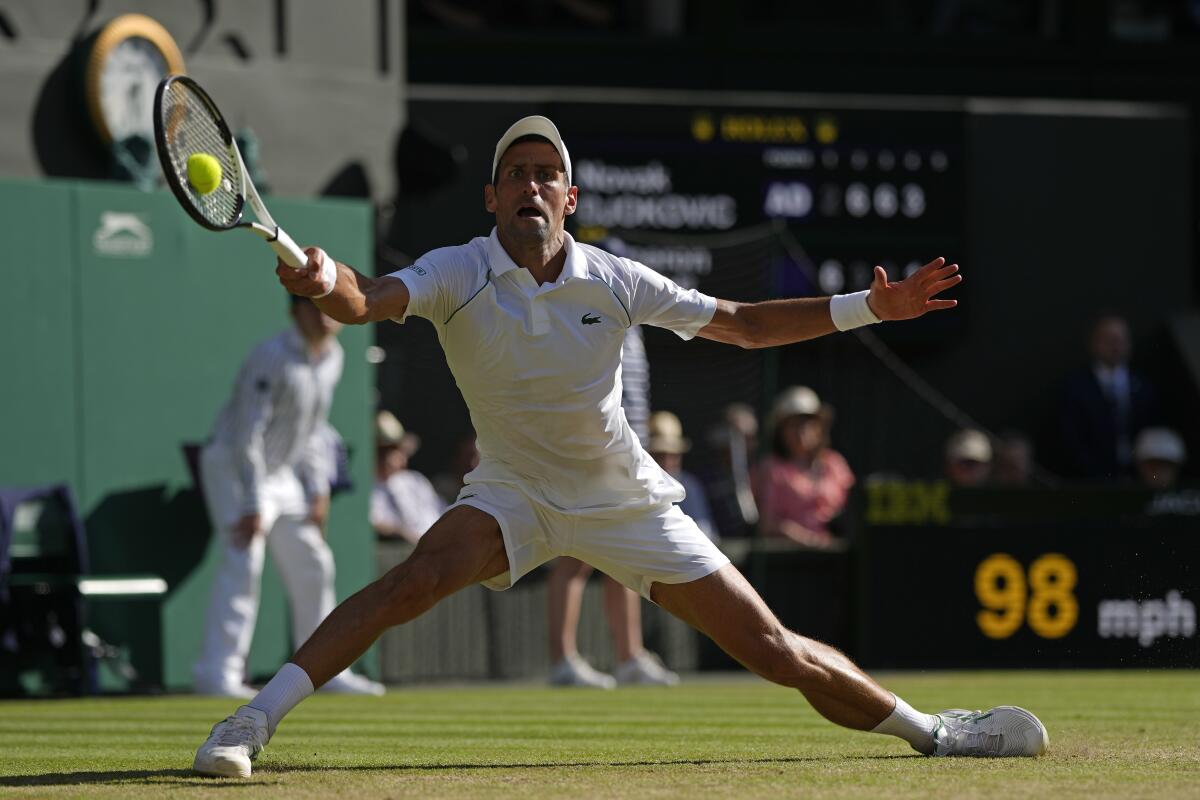 Serbia's Novak Djokovic returns to Britain's Cameron Norrie in a men's singles semifinal. 